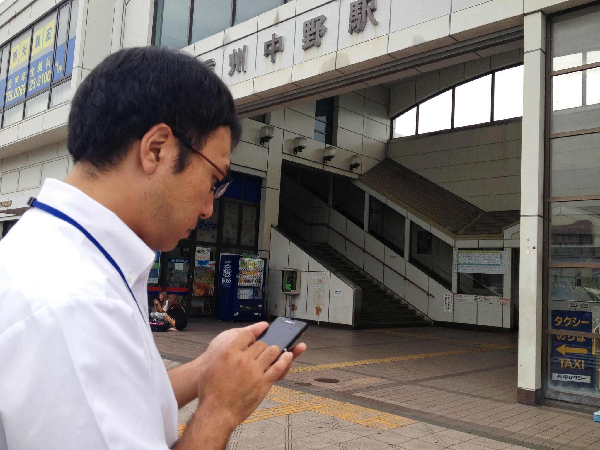 スマートフォンでガイドを作成する広報係の市職員