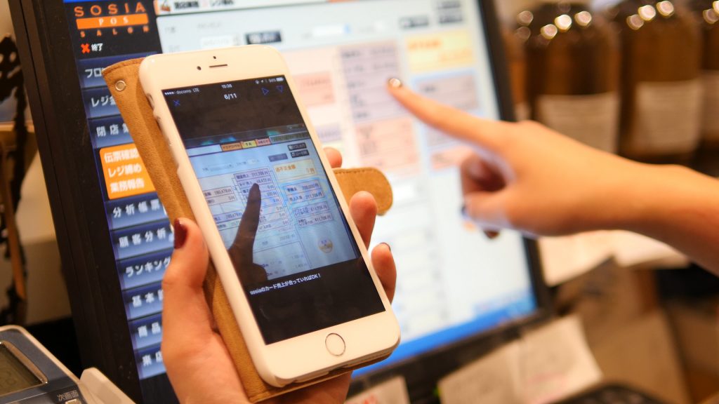 株式会社MASHUにおけるスマートフォンでTeachme Bizを参照しながらのレジ業務場面