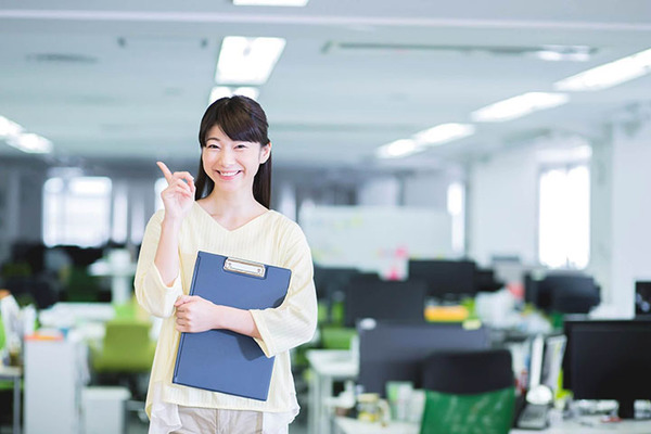オフィスの中でバインダーを持つ女性の画像